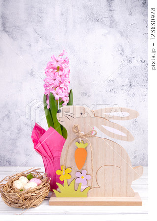 Easter wooden bunny and pink hyacinth flower in pot. 123630928