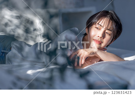 ベッドに横たわる女性　エモい斜光 123631423