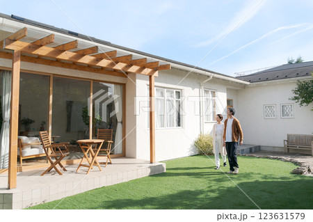 綺麗な家の庭に立つ夫婦 123631579