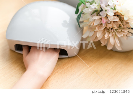 ネイルライトでジェルネイルを硬化させる女性（ネイルマシン・ネイルサロン・セルフネイル） 123631846