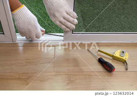 Worker adjust roller of aluminium sliding  window. 123632014