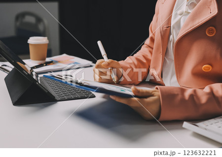 Cropped image of professional businesswoman working at her office via laptop, young female manager using portable computer device while sitting at modern loft, flare light, work process concept 123632221