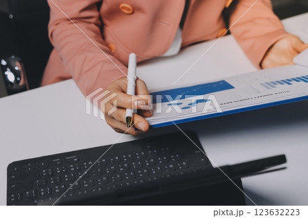 Cropped image of professional businesswoman working at her office via laptop, young female manager using portable computer device while sitting at modern loft, flare light, work process concept 123632223