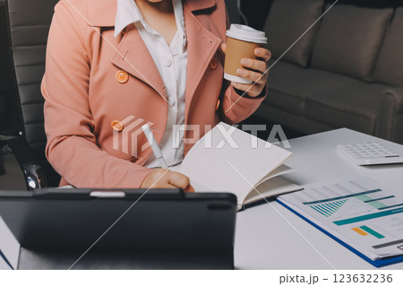 Cropped image of professional businesswoman working at her office via laptop, young female manager using portable computer device while sitting at modern loft, flare light, work process concept Cropped image of professional businesswoman working at her office via laptop, young female manager using portable computer device while sitting at modern loft, flare light, work process concept 123632236
