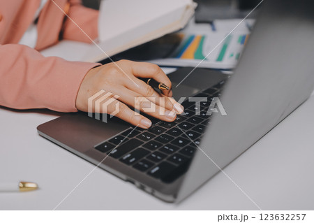 Cropped image of professional businesswoman working at her office via laptop, young female manager using portable computer device while sitting at modern loft, flare light, work process concept 123632257