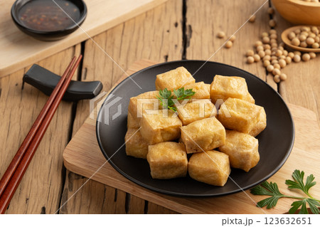 Crispy Air Fryer Tofu,Healthy cooked soybean block tofu used airfryer in black plate with chilli sweet sauce. 123632651