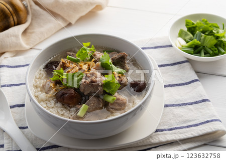 Pork Porridge.Boiled rice with Pork Baby Back Ribs or pork cartilage with shitake mushroom in white bowl.Asian breakfast style Pork Porridge.Boiled rice with Pork Baby Back Ribs or pork cartilage with shitake mushroom in white bowl.Asian breakfast style 123632758