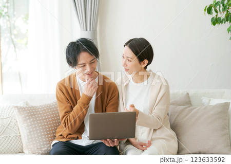 ソファに座ってパソコンを見る夫婦 123633592
