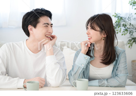 リビングでくつろぐ見つめ合う若いカップル リビングでくつろぐ見つめ合う若いカップル 123633606