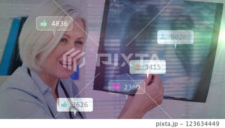 Social media engagement image over smiling doctor pointing at screen 123634449