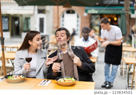 European couple sitting on the terrace of the restaurant and chatting 123634501