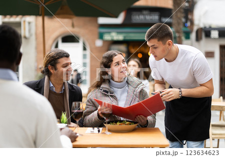 Couple husband and wife ordering from boyfriend waiter in restaurant 123634623