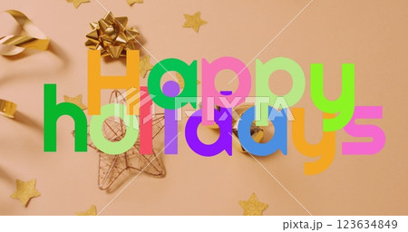 Image of colorful happy holidays text banner over christmas decorations on pink background 123634849
