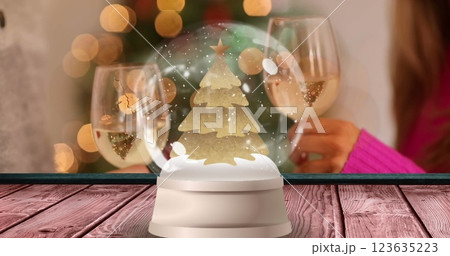 Image of stars falling and globe over snow globe with spots of light 123635223