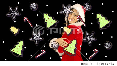 Image of snow and christmas decorations falling over caucasian woman dressed in santa hat Image of snow and christmas decorations falling over caucasian woman dressed in santa hat 123635713