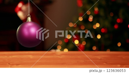 Image of shiny purple christmas bauble over defocussed fairy lights flashing on tree 123636053