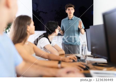 Young guy speaker stands in front of students and talks about use of artificial intelligence Young guy speaker stands in front of students and talks about use of artificial intelligence 123636449