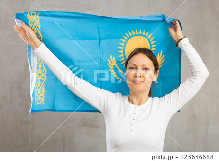 Joyful female fan of favorite team of Kazakhstan with the national flag in her hands Joyful female fan of favorite team of Kazakhstan with the national flag in her hands 123636688