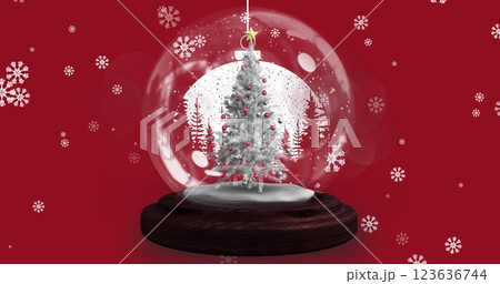 Image of snow globe with christmas tree over snow falling 123636744