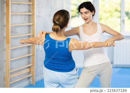 Women exercising armlock grip while sparring in sport gym 123637189