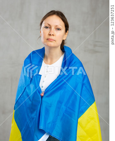 Sad worried woman tensely displaying ukrainian flag Sad worried woman tensely displaying ukrainian flag 123637251