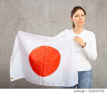 Adult sad woman holding Japan flag Adult sad woman holding Japan flag 123637378