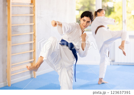 Two women training karate techniques in studio Two women training karate techniques in studio 123637391