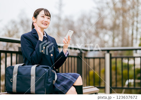 待ち合わせするベンチに座る高校生・中学生の女の子 待ち合わせするベンチに座る高校生・中学生の女の子 123637672
