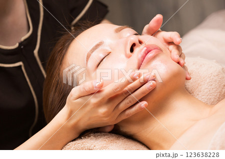若いアジア人女性はフェイシャルマッサージを受けています。 若いアジア人女性はフェイシャルマッサージを受けています。 123638228