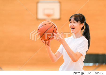 体育館でバスケットをする体操着姿の女子中学生・女子高生 体育館でバスケットをする体操着姿の女子中学生・女子高生 123638517