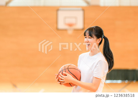 体育館でバスケットをする体操着姿の女子中学生・女子高生 体育館でバスケットをする体操着姿の女子中学生・女子高生 123638518