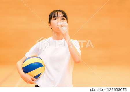 運動中に水分補給する体育館でバレーボールをする体操着姿の女子中学生・女子高生 123638673