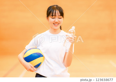 運動中に水分補給する体育館でバレーボールをする体操着姿の女子中学生・女子高生 123638677