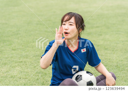 サッカー観戦で応援するユニフォーム姿の女性サポーター 123639494