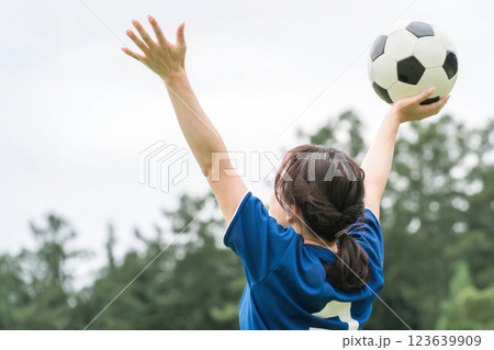 サッカーボールを持つ・かがげる女性の後ろ姿 サッカーボールを持つ・かがげる女性の後ろ姿 123639909
