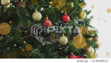 Christmas tree decorated with baubles, with a digital image of multiple yellow spots in the backgrou Christmas tree decorated with baubles, with a digital image of multiple yellow spots in the backgrou 123640913