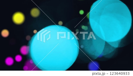 Image of snowflakes icons falling over colorful spots of light against black background 123640933