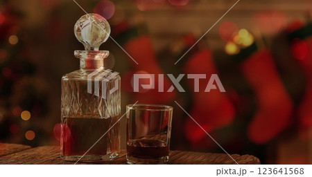 Image of wine decanter and glass, christmas stockings hanging 123641568