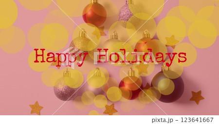 Image of happy holidays text over christmas baubles 123641667