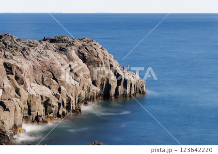 岩の先端で釣りをする人、長秒露光 123642220