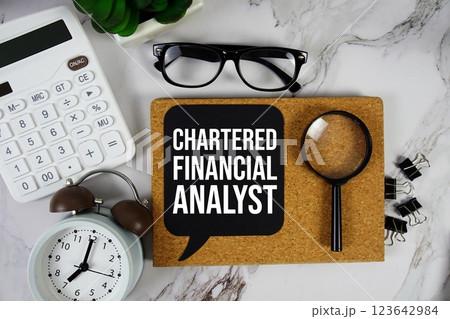 Chartered Financial Analyst text on speech bubble with alarm clock, calculator and magnifying glass on marble background 123642984