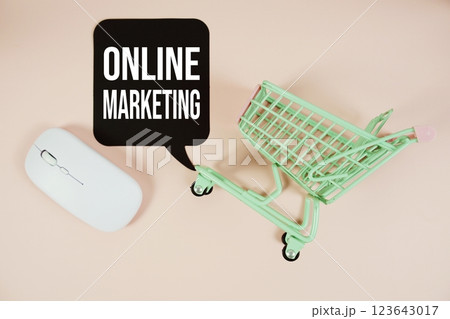 Online Marketing text on speech bubble with optical mouse and trolley shopping cart on pink background Online Marketing text on speech bubble with optical mouse and trolley shopping cart on pink background 123643017