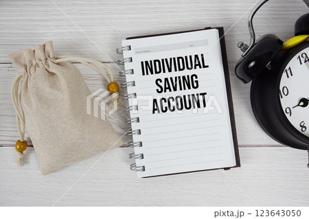 Individual Saving Account text on notepad with money bag and alarm clock on wooden background 123643050