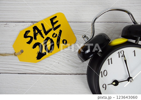 Sale 20% on price tag with alarm clock on wooden background 123643060