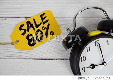 Sale 80% on price tag with alarm clock on wooden background Sale 80% on price tag with alarm clock on wooden background 123643063