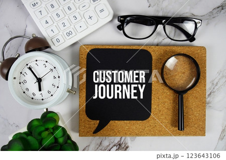 Customer Journey text on speech bubble with alarm clock, calculator and magnifying glass on marble background Customer Journey text on speech bubble with alarm clock, calculator and magnifying glass on marble background 123643106