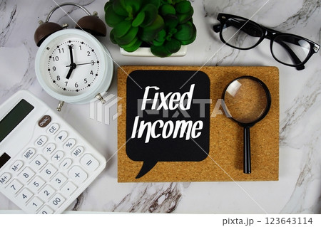 Fixed Income text on speech bubble with alarm clock, calculator and magnifying glass on marble background Fixed Income text on speech bubble with alarm clock, calculator and magnifying glass on marble background 123643114