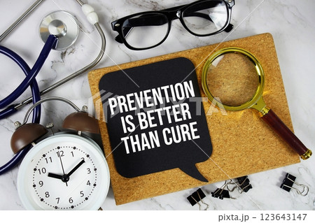 Prevention Is Better Than Cure text on speech bubble with alarm clock, magnifying glass and stethoscope on marble background 123643147
