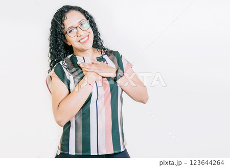 Grateful young woman smiling with hands on chest isolated. Positive smiling girl with hands on chest. Grateful people with hands on chest Grateful young woman smiling with hands on chest isolated. Positive smiling girl with hands on chest. Grateful people with hands on chest 123644264