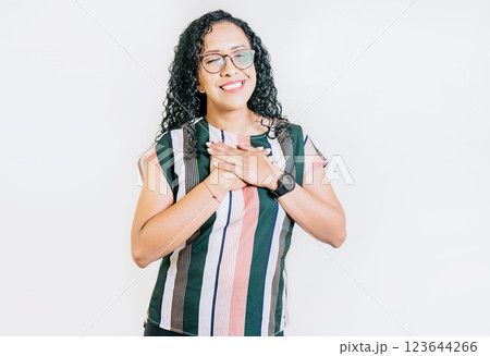 Positive smiling girl with hands on chest. Grateful people with hands on chest. Grateful young woman smiling with hands on chest isolated Positive smiling girl with hands on chest. Grateful people with hands on chest. Grateful young woman smiling with hands on chest isolated 123644266